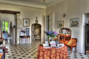 Una habitación con una mesa con un jarrón de flores. en Château De Blavou Normandie en Saint-Denis-sur-Huisne