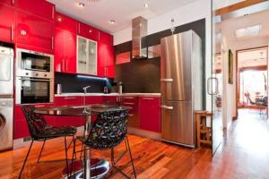 マドリードにある3Bedrooms 2Bathrooms furnished - Lavapies - brightのキッチン(赤いキャビネット、テーブル、椅子付)