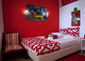 um quarto vermelho com uma cama e uma cadeira em Anastasias Apartments em Iria