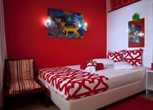 イリアにあるAnastasias Apartmentsの赤いベッドルーム(ベッド1台、椅子付)