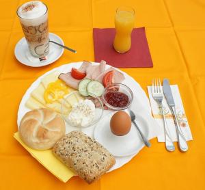 een bord ontbijtproducten met eieren, brood en fruit bij Hotel Bergkristall in Schwarzenberg am Bohmerwald