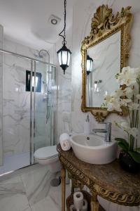 bagno con lavandino, servizi igienici e specchio di the gallery Studios II a Porto