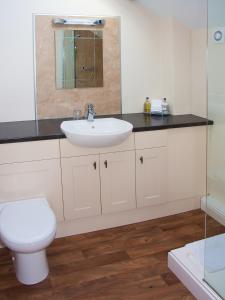 a bathroom with a white sink and a toilet at Ghyll Farm B & B in Lamplugh