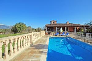 a villa with a swimming pool in front of a house at Villa Tramuntana in Inca