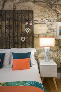 a bedroom with a bed and a stone wall at the gallery Studios II in Porto