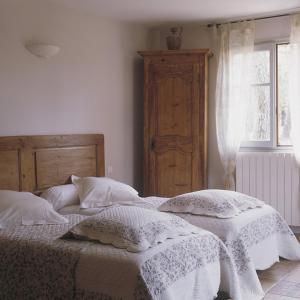 FauconにあるLe Mas de la Pinèdeのベッドルーム1室(枕2つ、窓付)