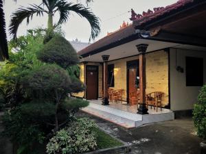 a house with a porch with a table and chairs at Wiran Homestay in Canggu