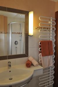 un bagno con lavandino, specchio e asciugamani di Villa Castelli a Schladming Altre 37 foto