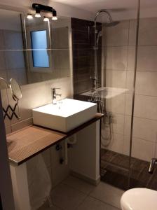 ein Bad mit einem Waschbecken und einer Dusche in der Unterkunft Renovated apartment in Athen
