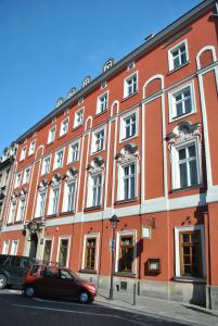 a red building with cars parked in front of it at Royal in Kraków