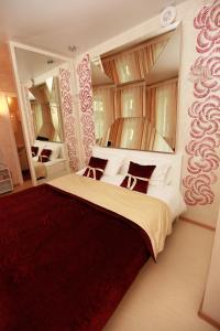 a bedroom with a large bed with two mirrors at Hotel Delight in Moscow