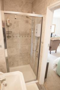 a bathroom with a shower and a sink at Weir Mill Farm in Cullompton