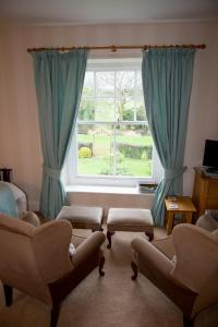 a living room with a large window with blue curtains at Weir Mill Farm in Cullompton
