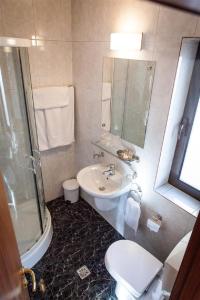 y baño con lavabo, aseo y ducha. en Tania-Frankfurt Hotel, en Bucarest