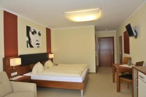 una camera da letto con un letto, una scrivania e un divano di Villa Castelli a Schladming
