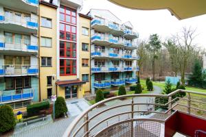 un edificio de apartamentos con ventanas azules y rojas y balcón en Baltic Apartments - Zdrojowa, en Świnoujście