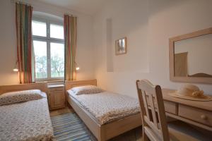 um quarto com 2 camas, uma secretária e um espelho. em Apartamenty Rybak 3 em Niechorze