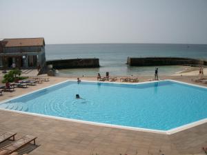 a large swimming pool next to a beach with people in it at Porto Antigo Three Bed Apartment with Sea View in Santa Maria