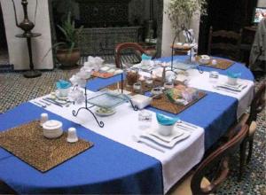a blue and white table with plates and dishes on it at Dar Melody in Fez