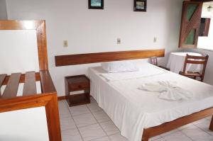 a bedroom with a bed with a wooden headboard at Pousada Do Bosque in Itajuípe