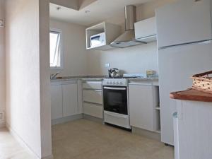 Departamentos Valeria Medanos في فاليريا ديل مار: مطبخ مع موقد وثلاجة