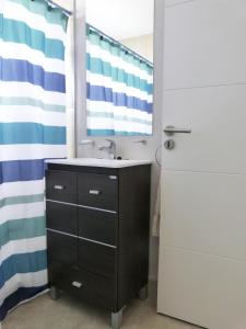 Departamentos Valeria Medanos في فاليريا ديل مار: حمام مزود بحوض ومِرآة