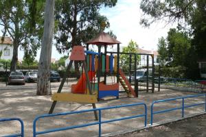 a playground with a colorful swing set in a park at Parque de Campismo Orbitur Evora in Évora