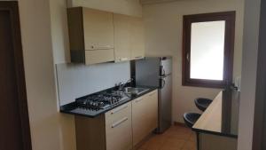 a small kitchen with a stove and a sink at Porto Antigo Three Bed Apartment with Sea View in Santa Maria
