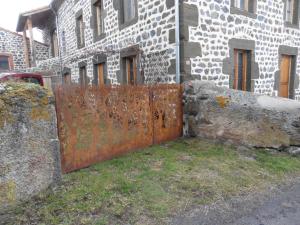 un ancien portail rouillé devant un bâtiment dans l'établissement La Loge, à Sanssac-lʼÉglise