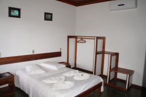 a bedroom with a bed with towels on it at Pousada Do Bosque in Itajuípe