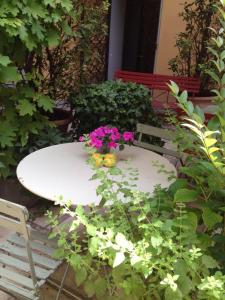Una mesa blanca con flores encima. en Albergo Residence Perosi, en Tortona