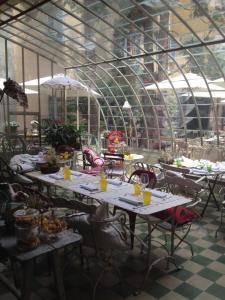 Albergo Residence Perosi في تورتونا: مجموعة طاولات في بيت زجاجي به طعام