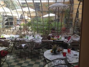 um restaurante com mesas, cadeiras e guarda-sóis em Albergo Residence Perosi em Tortona