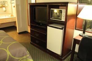 a hotel room with a microwave and a tv at Super 8 by Wyndham Bossier City/Shreveport Area in Bossier City