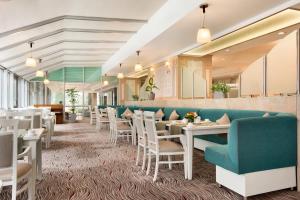 a dining room with white tables and chairs at Wyndham Tashkent in Tashkent
