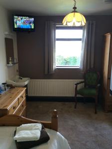 a bedroom with a bed and a sink and a window at Stone Cottage in Ponteland