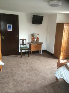 龐蒂蘭的住宿－斯圖旅館，配有桌子、椅子和镜子的房间