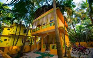 a yellow building with palm trees in front of it at Orange Villa in Morjim