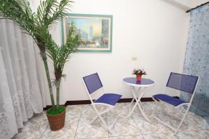 a room with two chairs and a table and a plant at Pomelo B&B in Dongshan