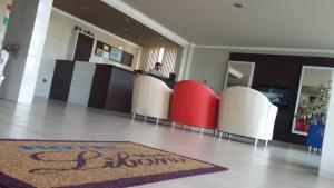 an empty lobby with red and white chairs and a rug at Hotel Monte Líbano in Laguna