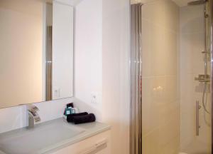 un bagno con doccia, lavandino e specchio di La Casa Cosy, Appart'Hôtel a Biarritz Altre 75 foto