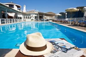a hat and sunglasses sitting next to a swimming pool at Hotel Chiaia Di Luna in Ponza
