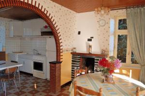 een keuken en eetkamer met een tafel en een open haard bij gîte dans Baie du Mont Saint- Michel in Vessey