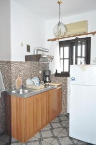 a kitchen with a sink and a refrigerator at Giannis Maria Apartments in Psakoudia