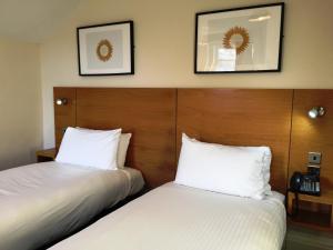 two beds in a hotel room with white sheets at Stotfield Hotel in Lossiemouth