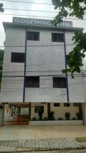 a tall white building with a sign on it at Golfinho Hotel (Adults Only) in São Vicente