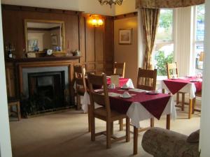 uma sala de jantar com uma mesa e cadeiras e uma lareira em Autumn Leaves Guest House em Whitby