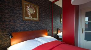 Un dormitorio rojo con una cama y una pared roja. en Residence Arx & Wellness, en Chrudim