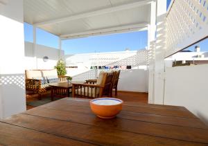 an orange bowl on a wooden table on a balcony at Apartamento Mariposa in Conil de la Frontera
