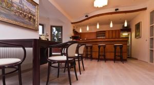 un bar con sillas y una barra en una habitación en Residence Arx & Wellness, en Chrudim
